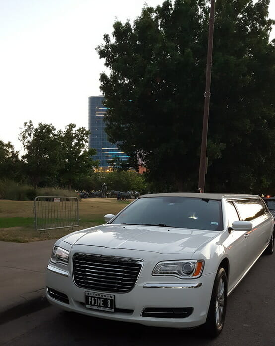 Front of white Chrysler 300 limo outside Pioneer Plaza during the day